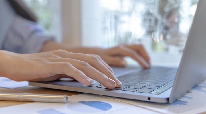 Hands typing on a laptop keyboard