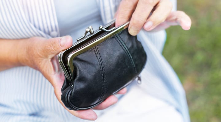 Hands of an elderly woman holding a purse