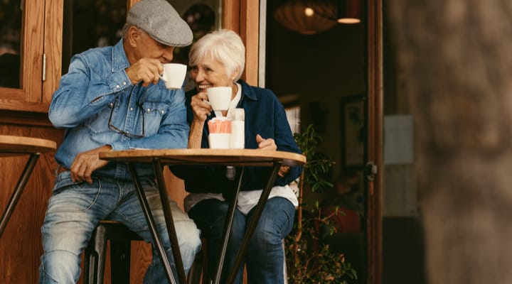 A senior couple enjoying a coffee outside of a cafe