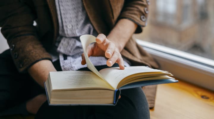 A close up of a man reading a book