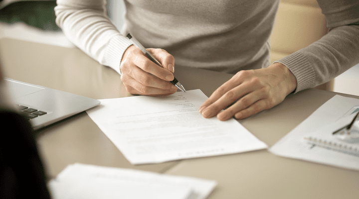 A woman signing some paperwork