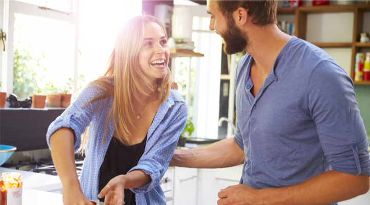 A young couple cooking together in their kitchen.