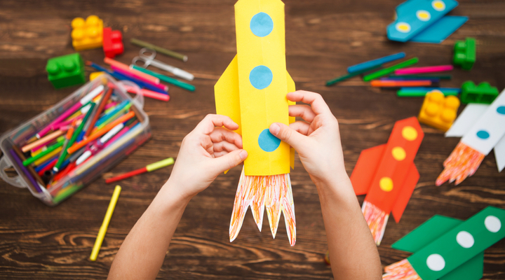 A child making a rocket out of paper.