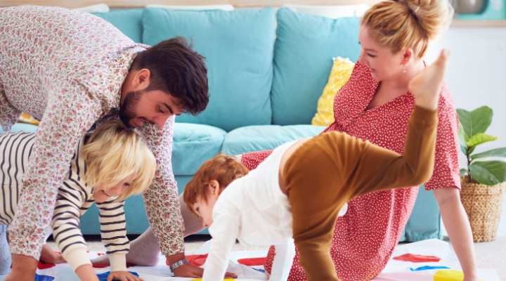 A family with young children playing Twister.