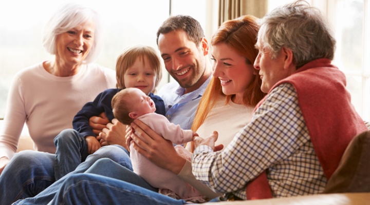 A multi-generational family sitting on the sofa.