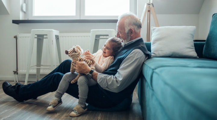 A grandfather playing with his granddaughter.