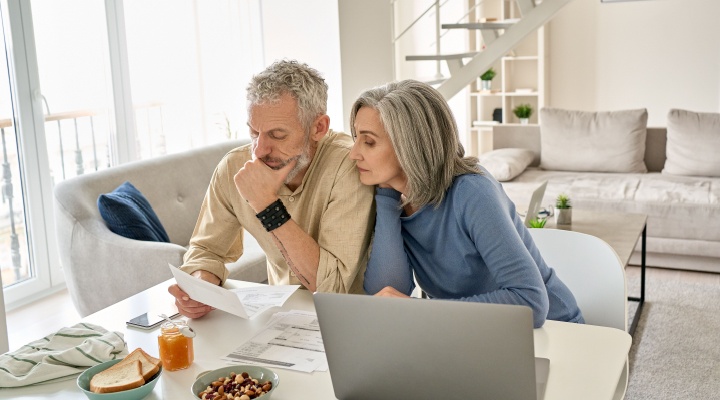 A couple looking at paperwork together in their home.