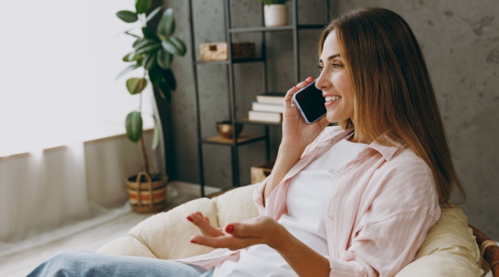 A woman talking on the phone at home.